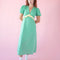 model wearing green puff sleeve v-neck midi dress with  pale yellow ruffle under the bust