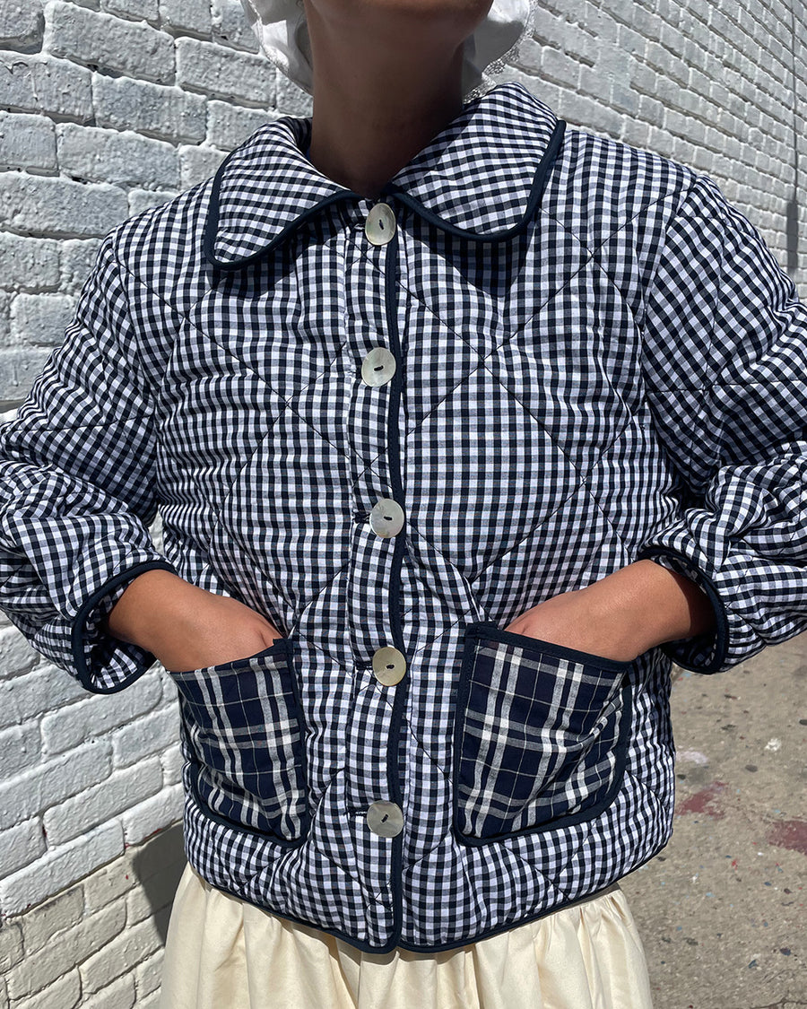 up close of model wearing blue checkered jacket with blue plaid front patch pockets and collar