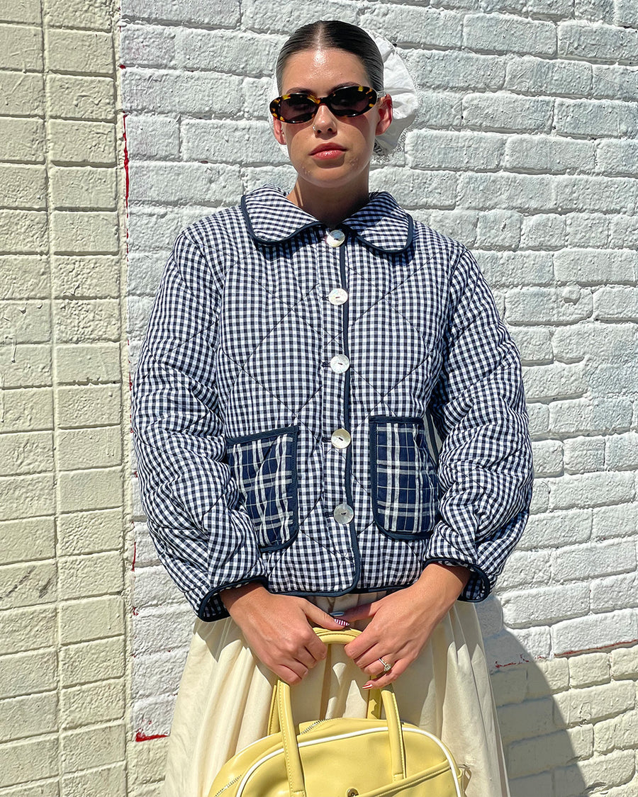 model wearing blue checkered jacket with blue plaid front patch pockets and collar