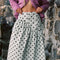 model wearing mint asymmetrical dot midi skirt with purple cardigan