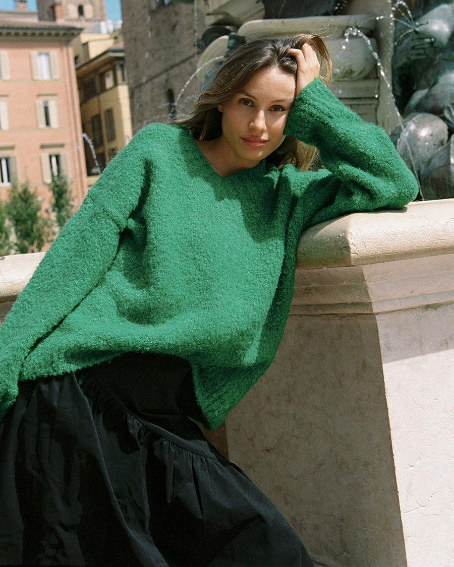 model wearing green textured v-neck sweater and twill skirt