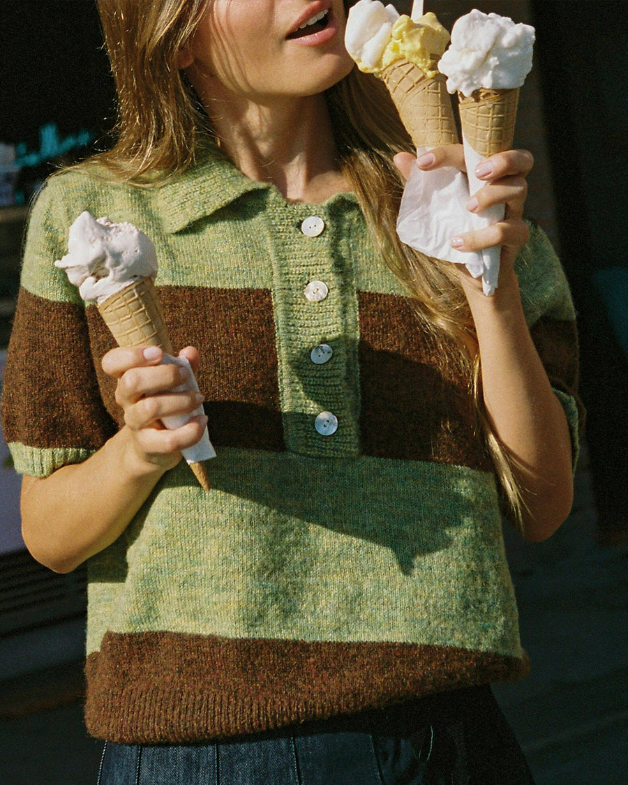 up close of model wearing brown and mint striped short sleeve polo sweater