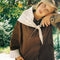 up close of model wearing brown oversized trench coat with white and dainty blue folk print tie shawl, arm and hem trim