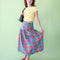 model wearing colorful plaid midi skirt with drop waist