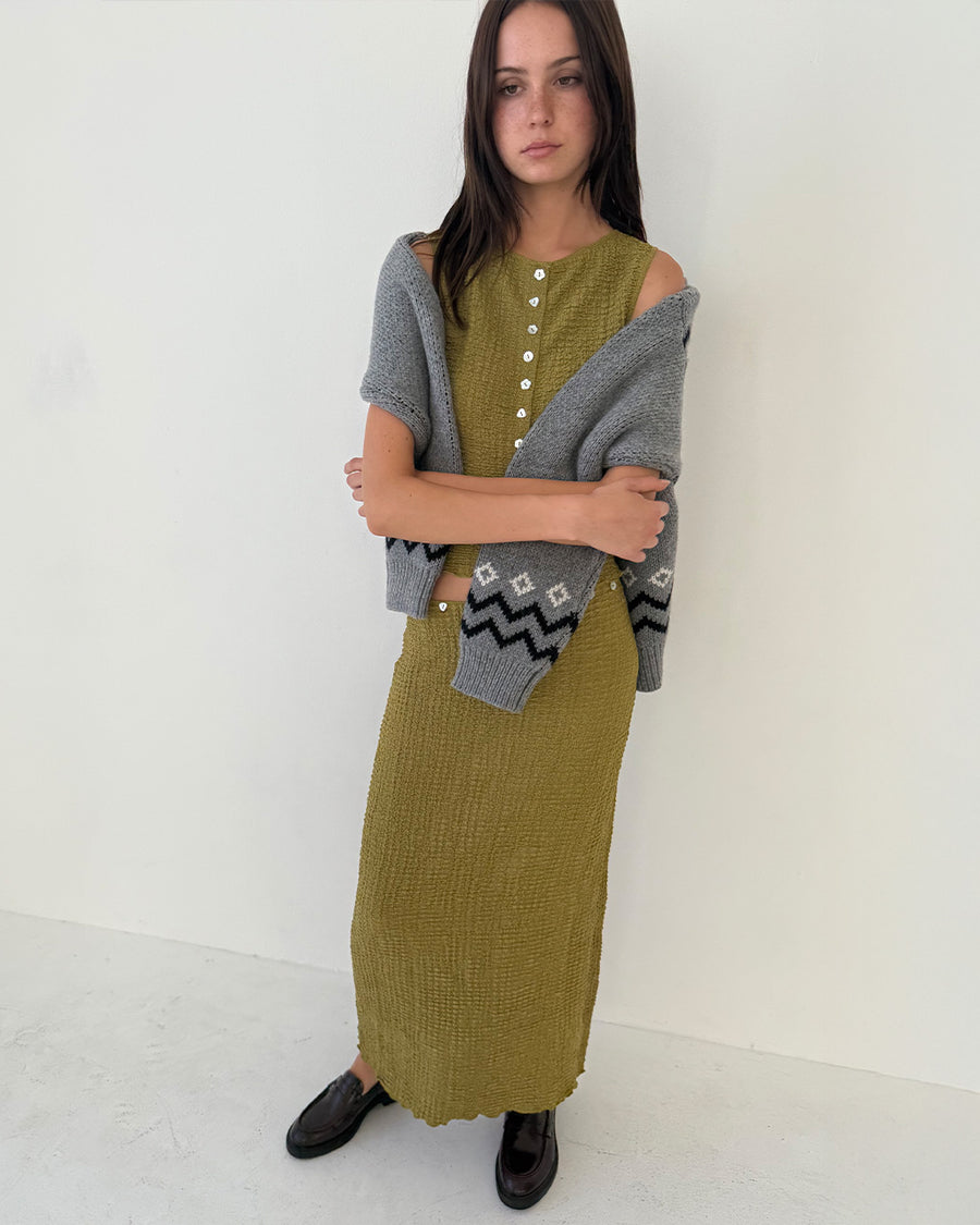 model wearing olive crinkle midi skirt with shaped shell buttons on the top and matching tank
