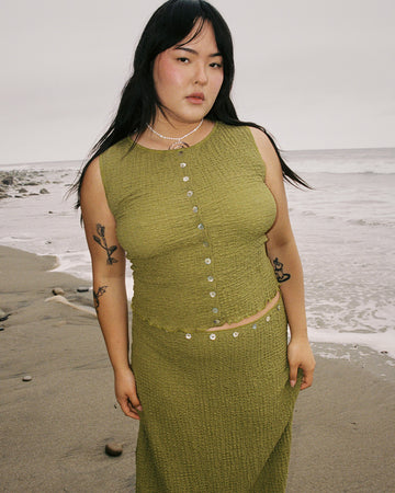 model wearing cropped olive crinkle button front tank with various shaped shell buttons