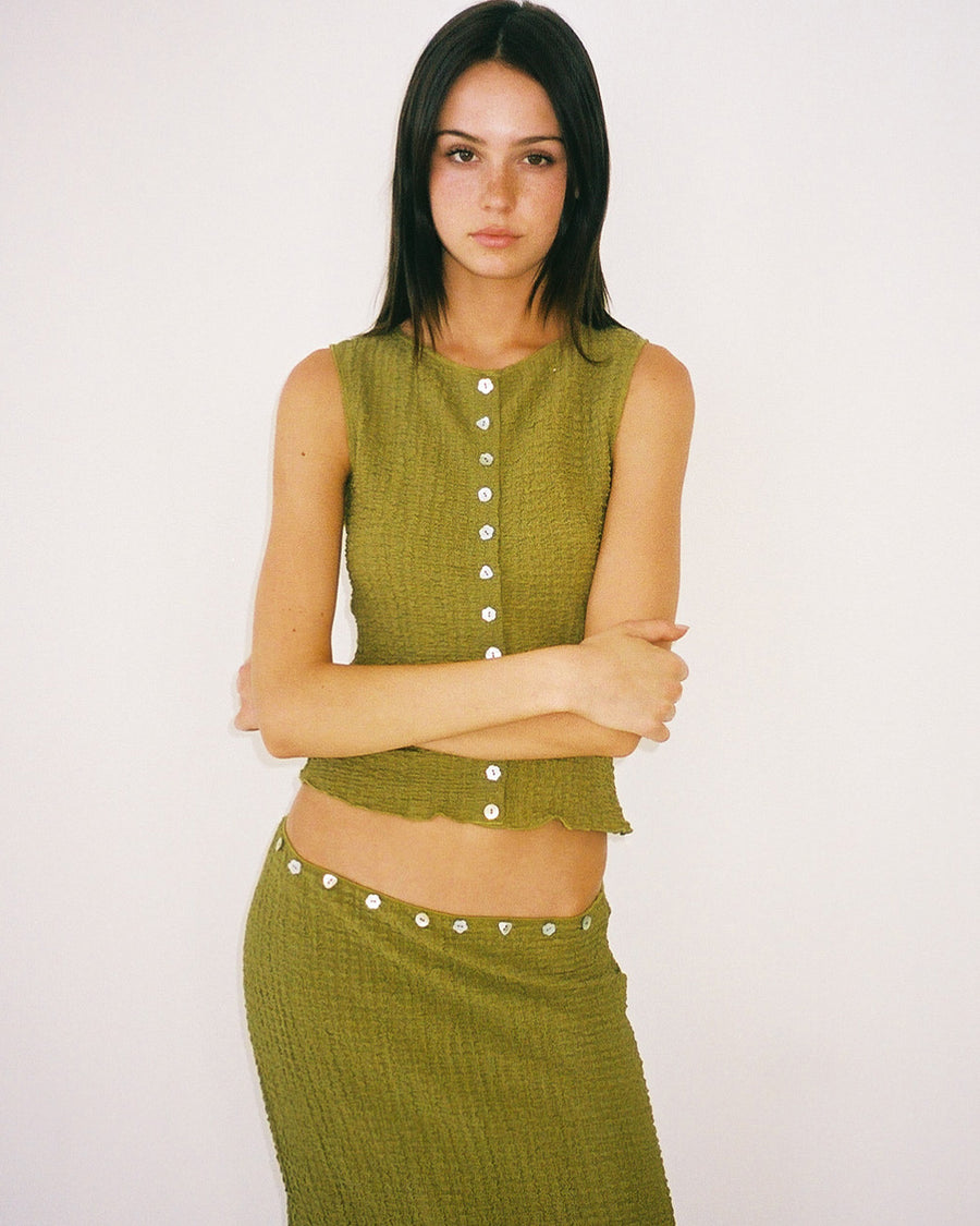 model wearing cropped olive crinkle button front tank with various shaped shell buttons