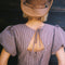back view of model wearing brown striped midi dress with puff sleeves, v-waistline and tie back