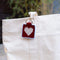 red needlepoint keychain kit with baby blue trim, tan heart and gold hardware on a tote bag