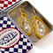 yellow orange oyster shaped dangle earrings with pearls in the center and matching tin holder