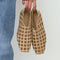 model holding natural suede flat with lattice detail