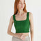 model wearing clover green structured sleeveless crop top with piping detail.