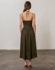 backview of model wearing olive green midi dress with boned corset bodice and two sets of straps