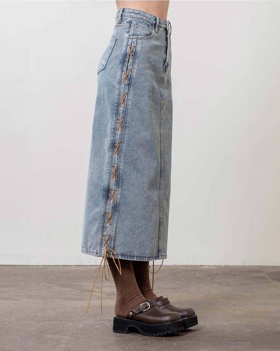 side view of model wearing light denim midi skirt with brown side tie details