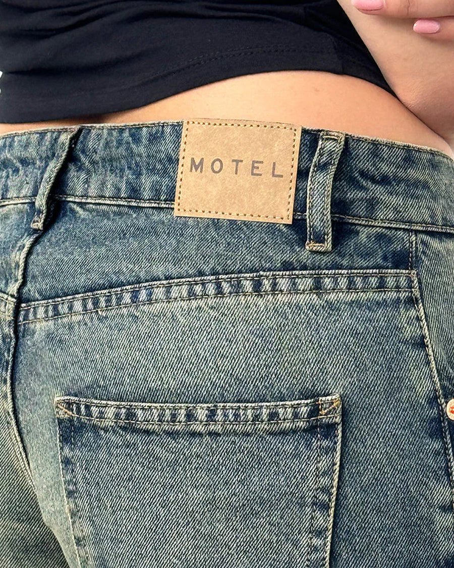 up close of back of  blueish-green low rise wide leg denim