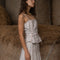 side view of model wearing light pink tank with side corset ties and vintage dainty floral wallpaper print