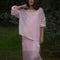 model wearing sheer pink oversized sweater over a pink midi dress