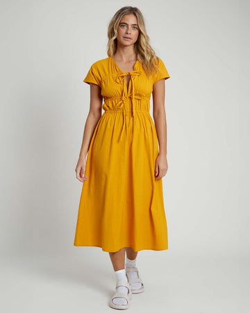 model wearing yellow seer sucker midi dress with short sleeves and two tie bodice front