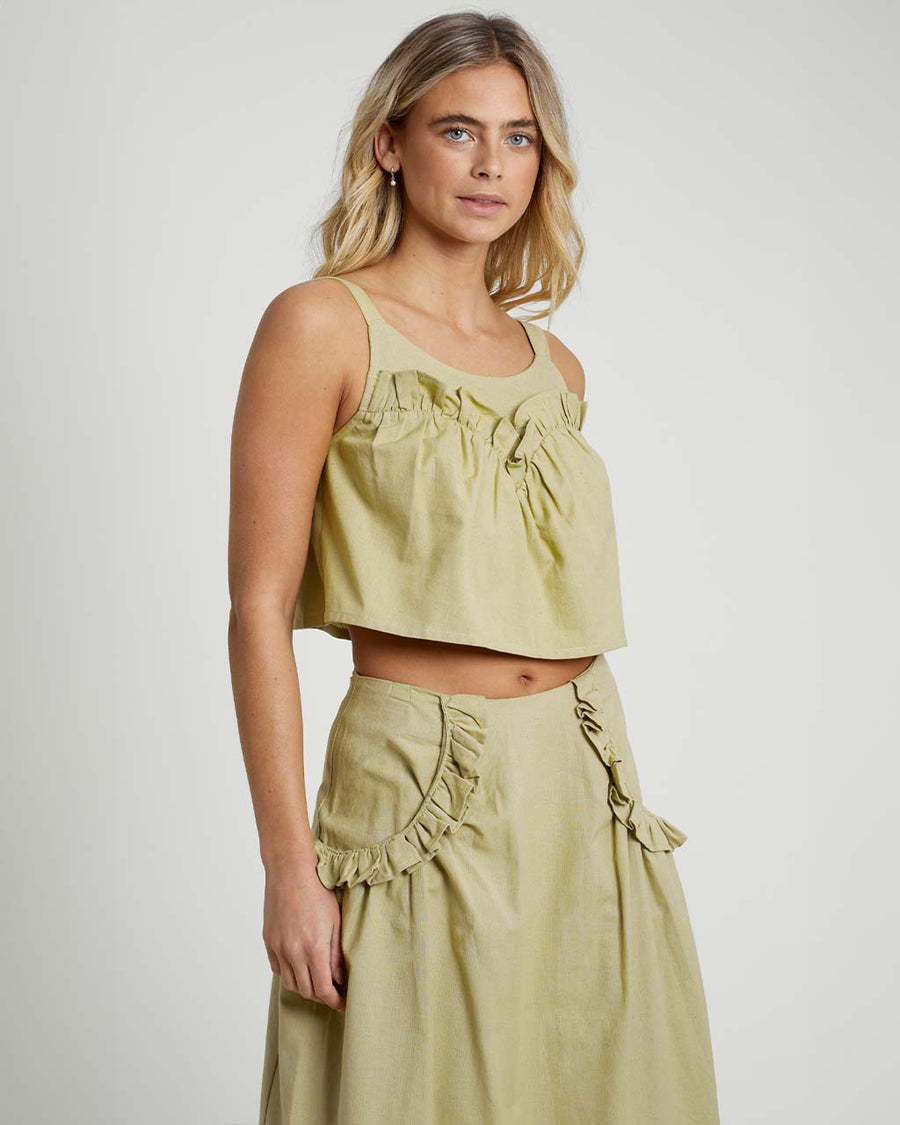 model wearing moss cropped linen tank with ruffle bust detail and matching midi skirt