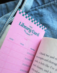 up close of purple library card reading tracker bookmark