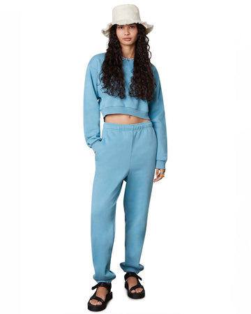 model wearing blue relaxed fit sweatpants and matching cropped sweatshirt