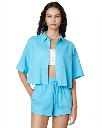 model wearing aqua linen cropped button down top and matching shorts