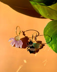 mix-match earrings: one pink flower dangle, and the other bee dangle