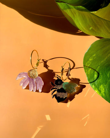 mix-match earrings: one pink flower dangle, and the other bee dangle