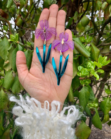 model holding large acrylic purple iris dangle earrings