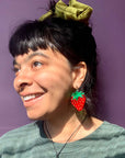 model wearing large strawberry shaped dangle earrings