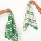 models holding cream hand towels with kelly green and lilac stripes (and the reversible side is green with cream and lilac stripes)