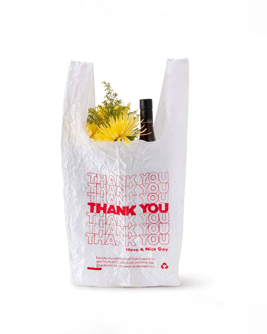 embroidered red thank you reusable bag with a bottle and flowers inside