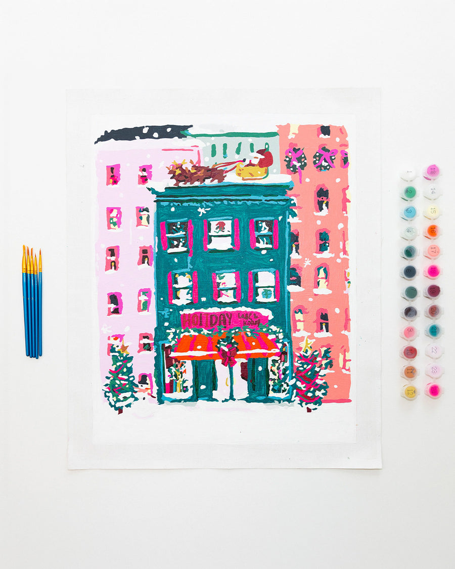 painted holiday bookstore paint by numbers kit with pots of paint and paintbrushes