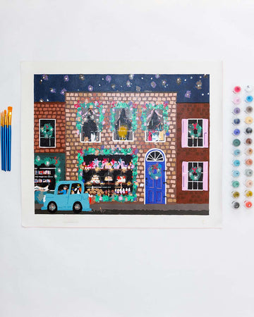 painted paint by numbers kit with holiday store front and brushes 