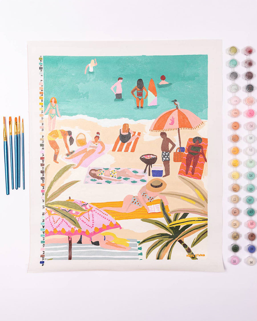 painted paint by numbers kit with a beach scene and includes 5 brushes and 24 pots of paint