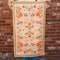 model holding yellow tea towel with colorful folk floral print
