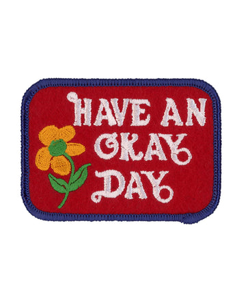 red rectangle patch with blue trim and white 'have an okay day' typography across the front
