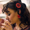 model wearing set of 2 red large button hair clips and matching earrings