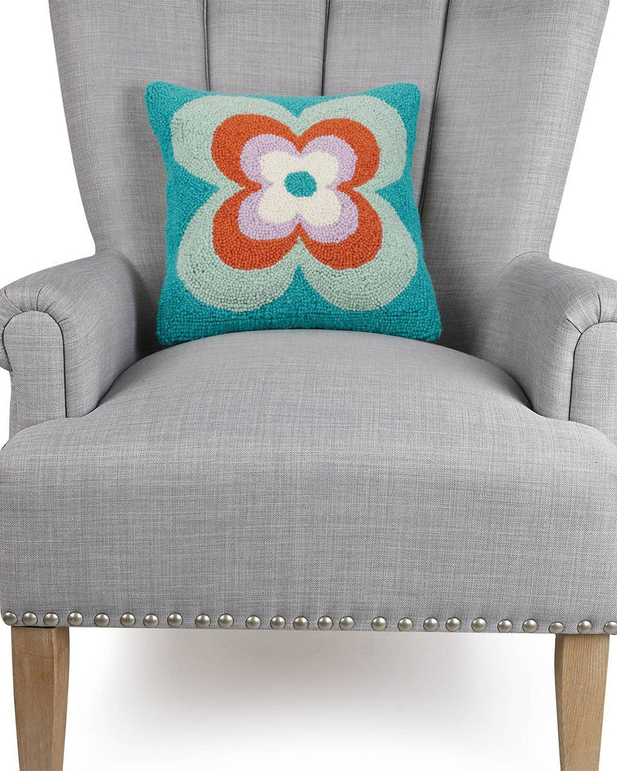 blue, green, rust and lavender abstract flower square throw pillow on chair