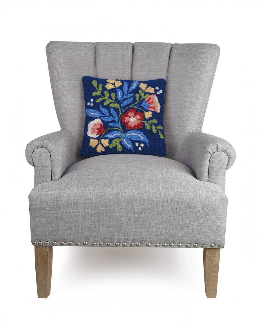 navy blues square pillow with colorful flowers bouquet print on a chair