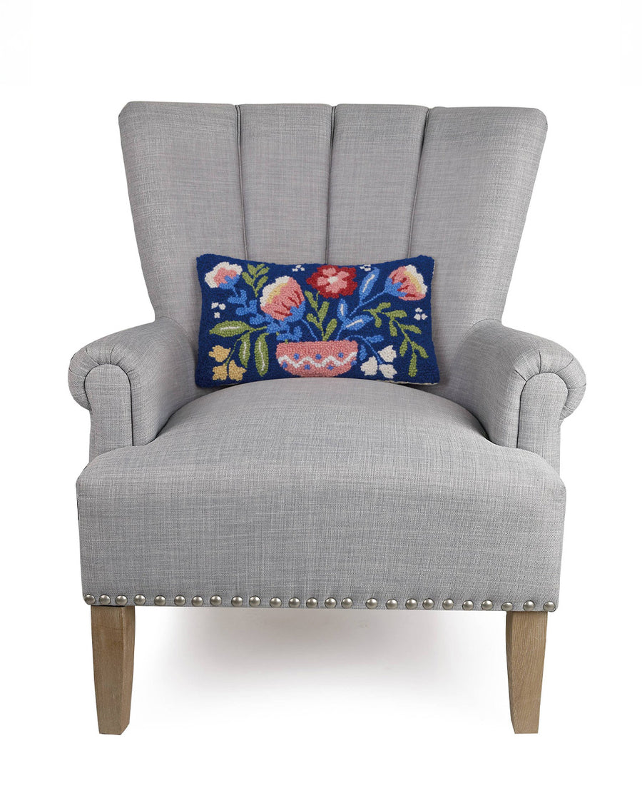 navy blue lumbar pillow with colorful flowers in a vase print on a chair