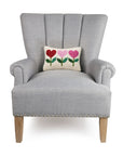 rectangle throw pillow with cream ground and pink and red heart flower design on chair