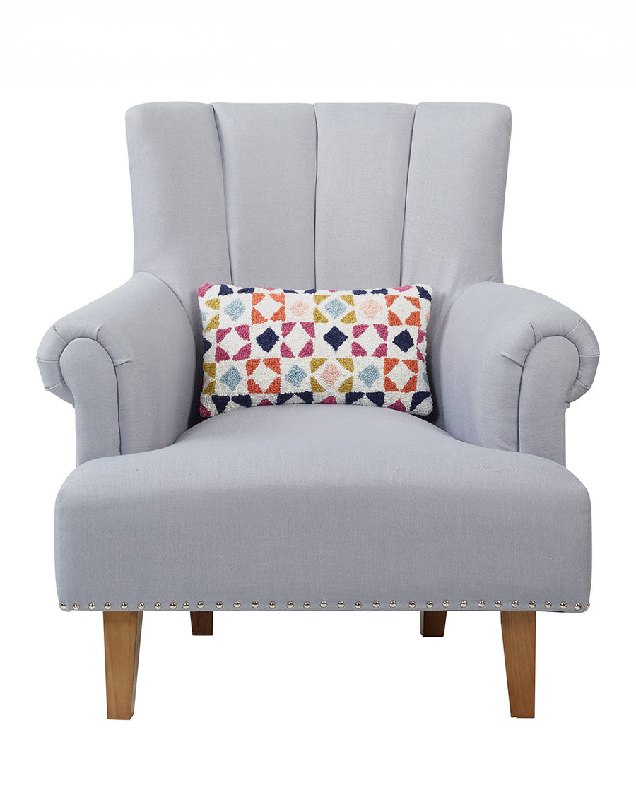 rectangular lumbar throw pillow with colorful quilted print on a chair
