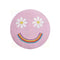 pink round smiley face pillow with flower eyes and rainbow smile