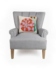 cream square throw pillow with colorful snail with pom pom eyes on chair