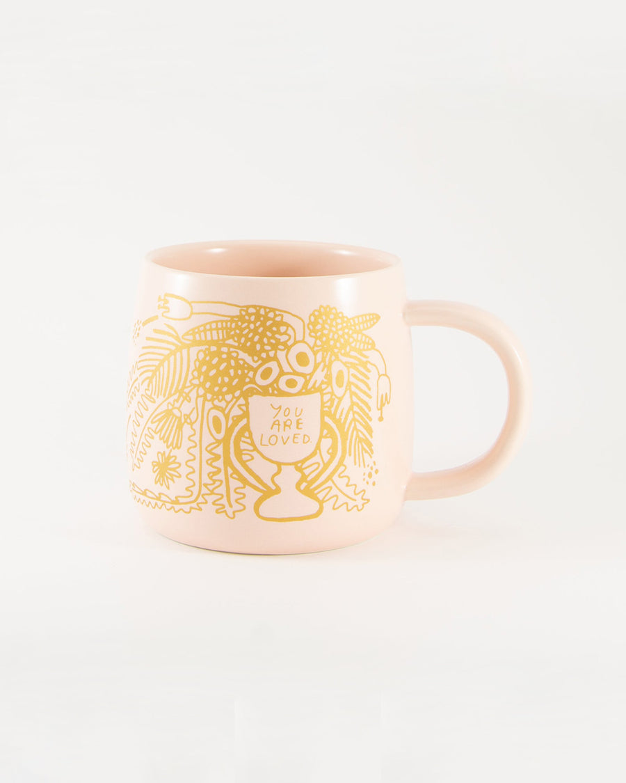 pink mug with gold 'you are loved' graphic