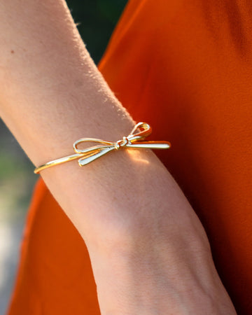 model wearing gold cuff with bow detail