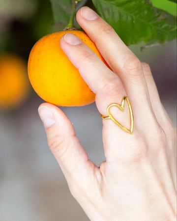 model wearing gold heart shaped ring