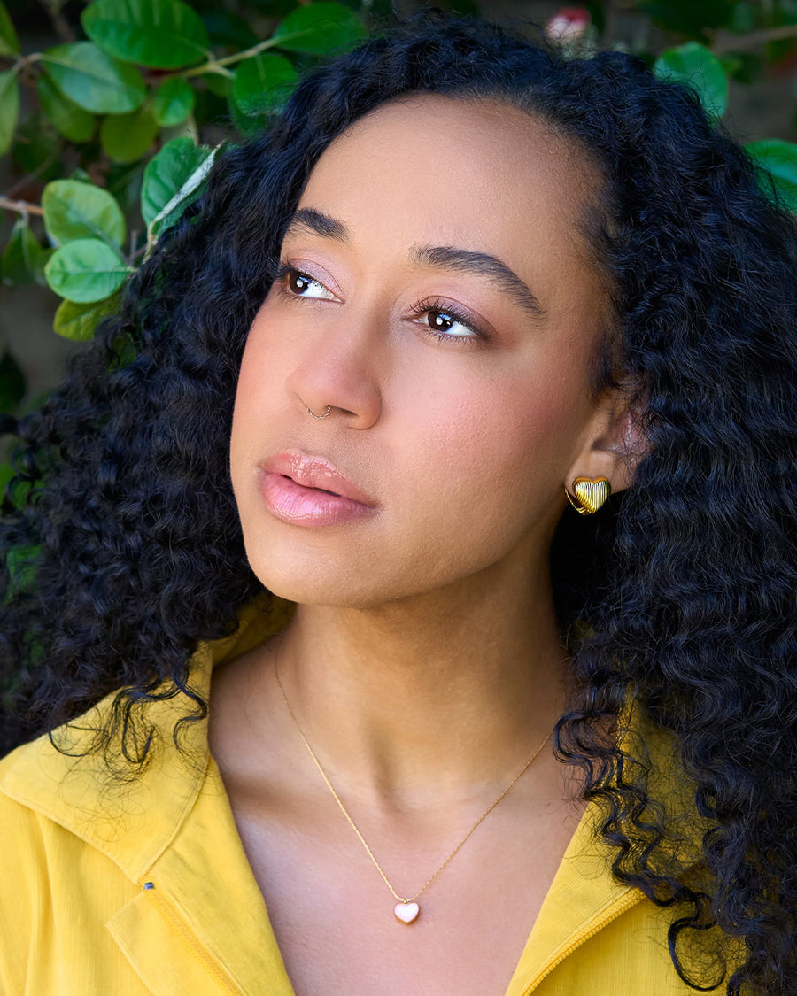 model wearing gold textured heart huggies