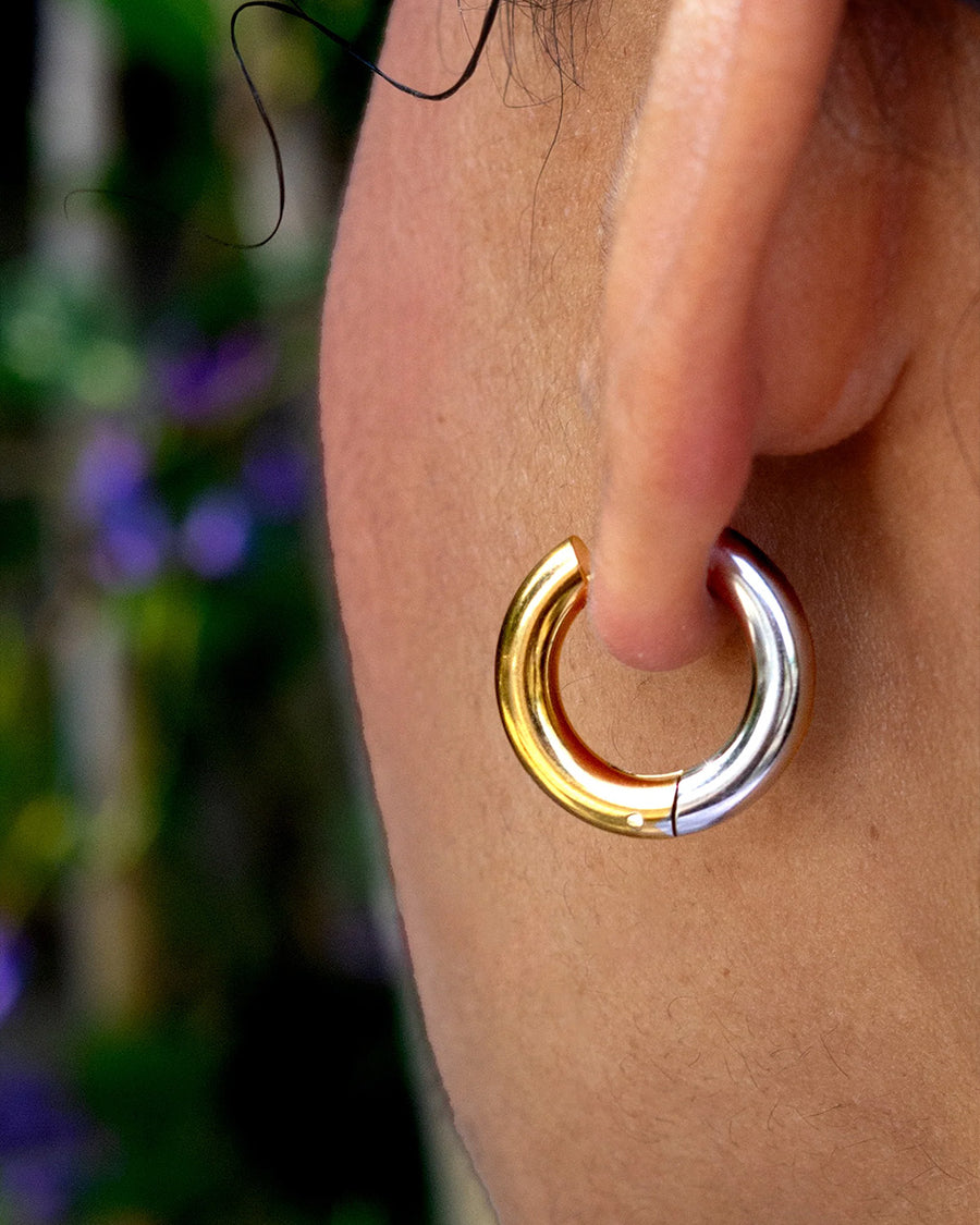 up close of model wearing two-toned gold and silver hoop earrings